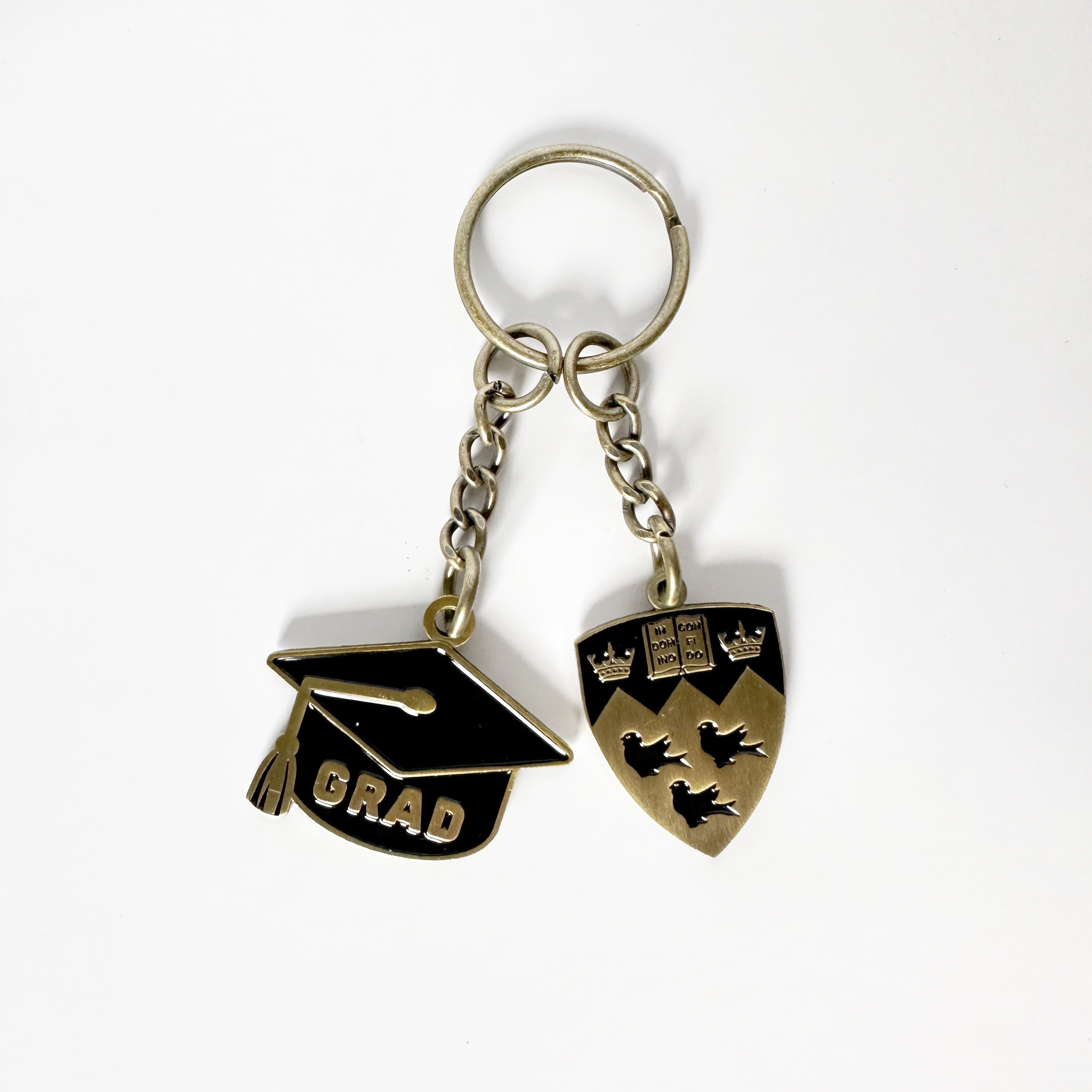 Gold finished keychain featuring a cut out grad cap and McGill crest on chain hardware